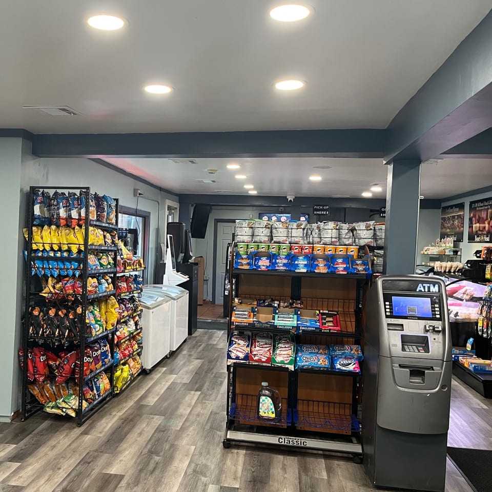 Interior of Country Corners Deli, featuring aisles of snacks, drinks, and an ATM.