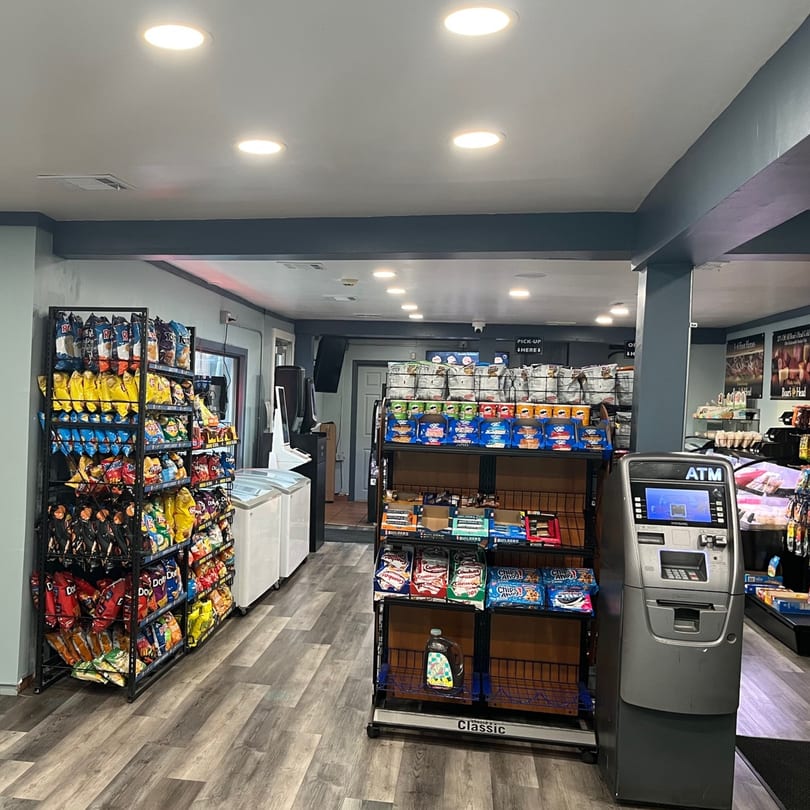Interior of Country Corners Deli, featuring aisles of snacks, drinks, and an ATM.